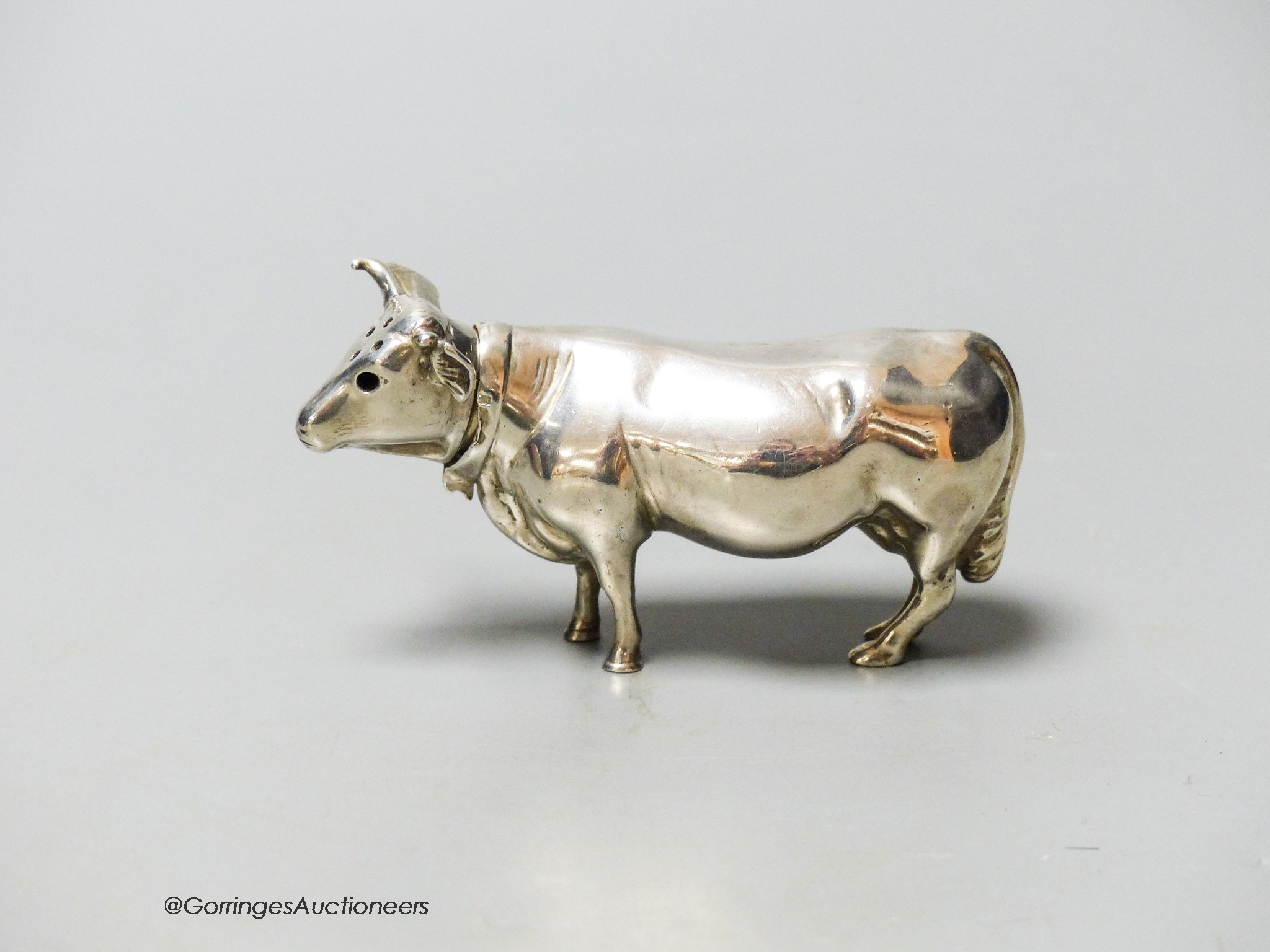 An Edwardian Hanau silver novelty silver pepper pot, modelled as a cow, Chester import marks for Berthold Muller, 1905, length 9cm, 62 grams.